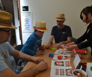 Art gallery-goers make origami boxes and cups for jelly beans at the opening of an origami exhibit at UC Santa Cruz. Photo by Marissa Fessenden